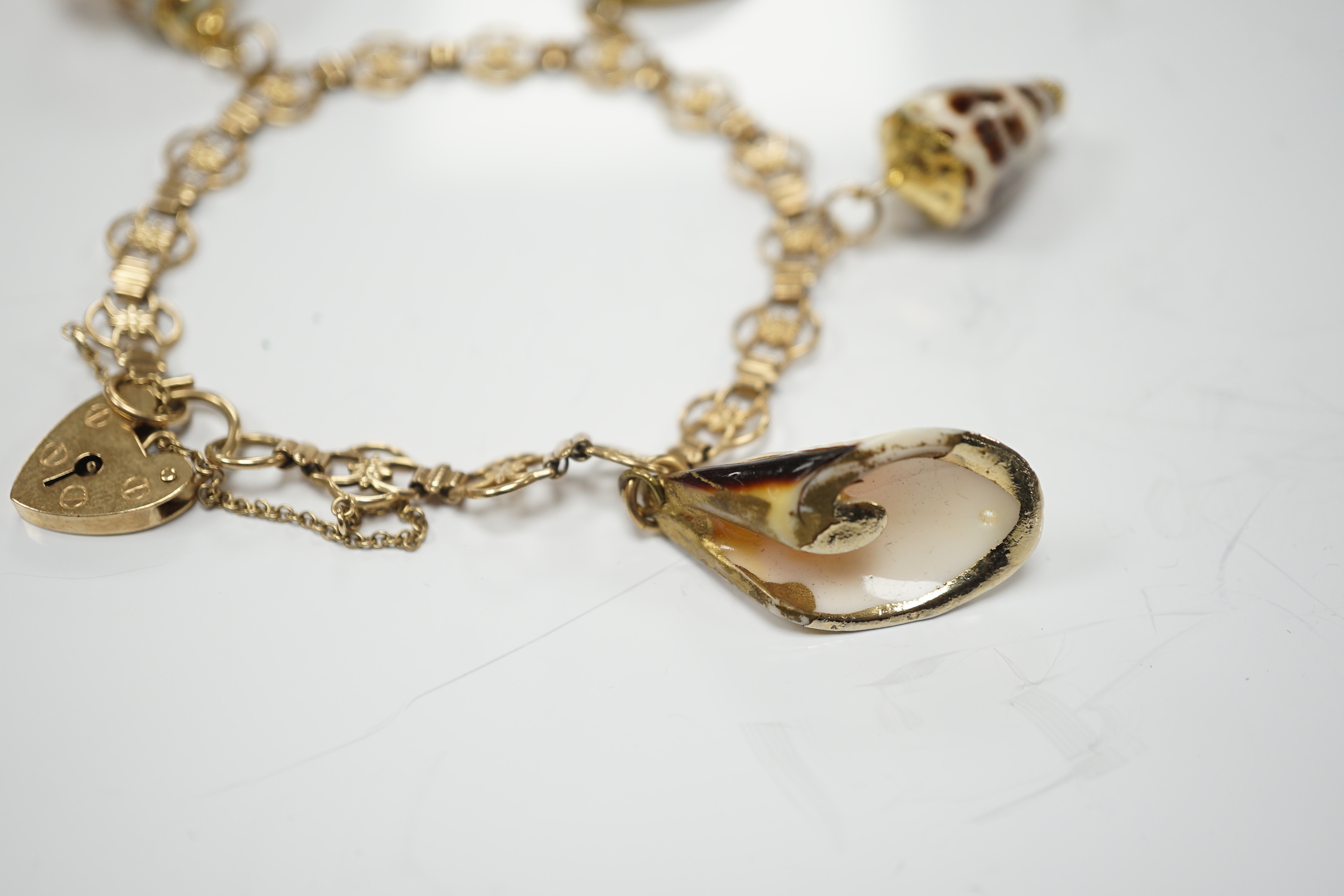 A modern 9ct gold charm bracelet hung with four shell charms, gross weight 19.1 grams.
